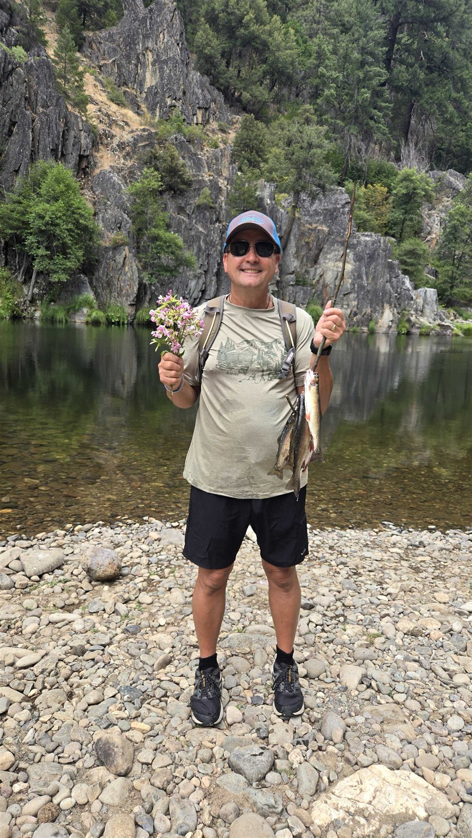 Larry smiling beside a mountain lake after a day of fishing